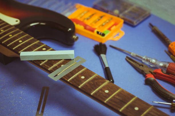 chitarra elettrica sulla scrivania di riparazione chitarra - workshop old fashioned old instrument maker foto e immagini stock