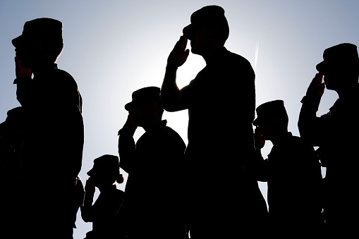 Several soldiers salute the flag at sunset during a military exercise. Army, Marines and Air Force were represented at the ceremony. 