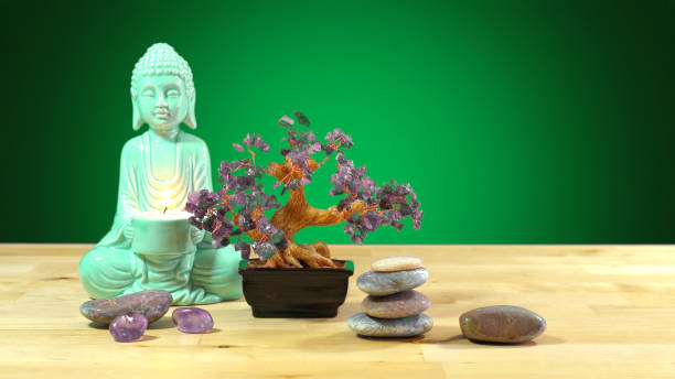 istock Calming zen interiors table setting with buddha statue holding burning candle 984610810