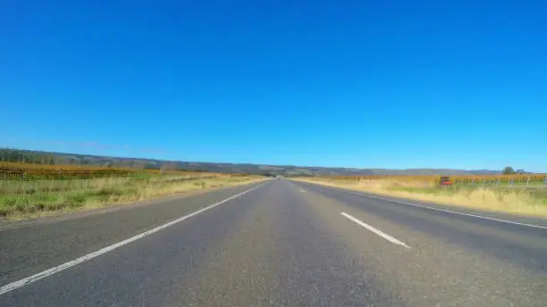 Vehicle POV, driving along wide, flat open highway through McLaren Vale South Australia.