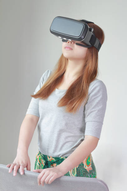 istock Young woman wearing virtual reality glasses at home. 984622214
