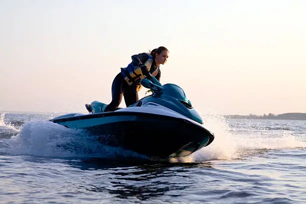 Photo of Woman on a jet ski in the ocean during the sunset