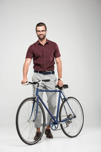 istock elegant smiling man posing with bicycle, isolated on grey 984632844