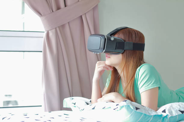 istock Young woman wearing virtual reality glasses at home. 984633088