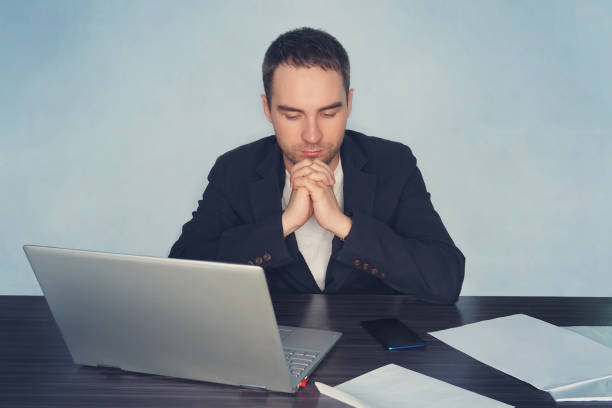 istock business, overwork, people, deadline and technology concept - stressed businessman with laptop computer thinking at office. a man prays for his business 984637384