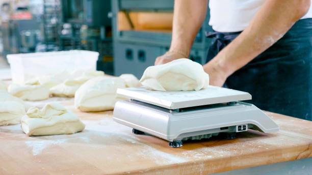 boulanger professionnel divise la pâte en portions et leur poids - serving size weight scale scale food photos et images de collection