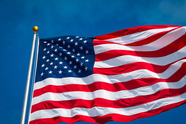 american flag with perfect blue sky background looking up at flagpole - american flag star shape striped fourth of july imagens e fotografias de stock