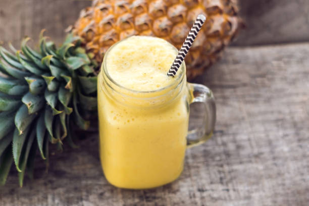 istock Pineapple smoothie with fresh pineapple on wooden table 984641280