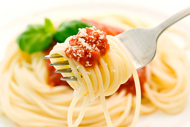 Spaghetti Napoli is rolled around a fork above the dish stock photo