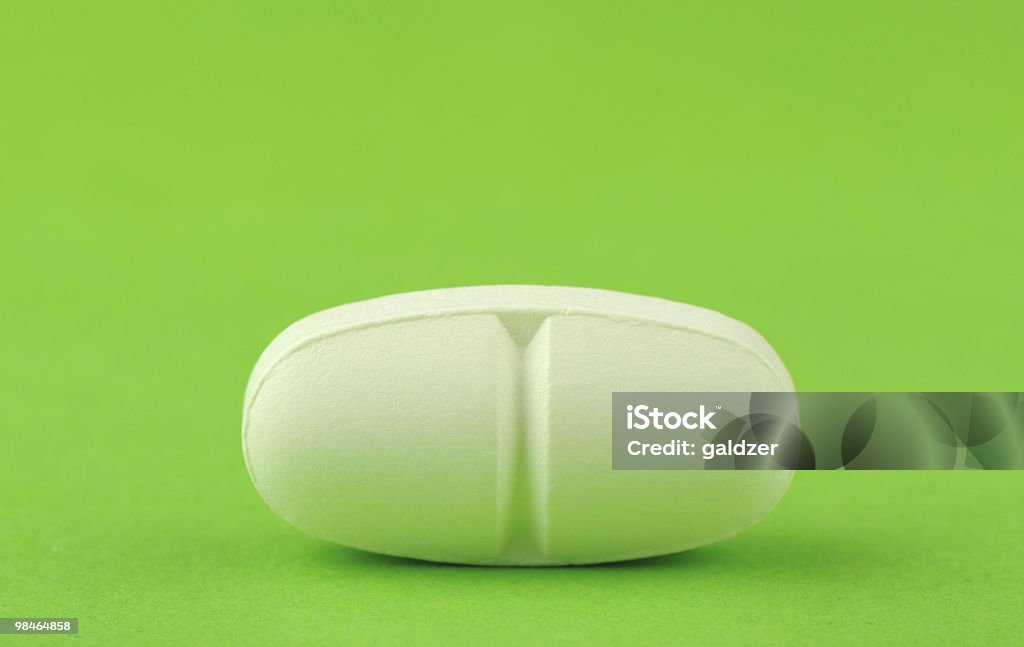 White tablet on a green background.  Antibiotic Stock Photo