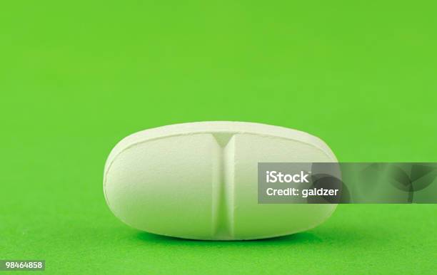 White Tablet On A Green Background Stock Photo - Download Image Now - Antibiotic, Capsule - Medicine, Close-up