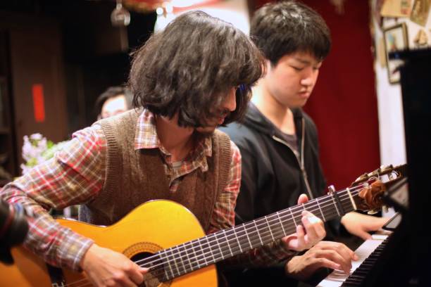 istock Young men playing piano and  guitar at bar 984658284