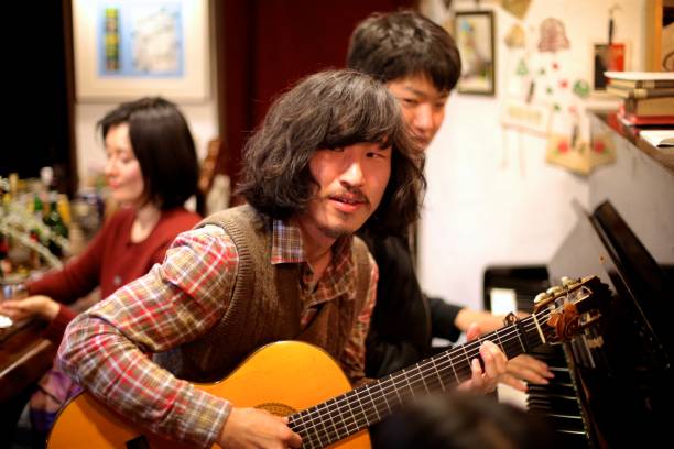 istock Young men playing piano and  guitar at bar 984660716
