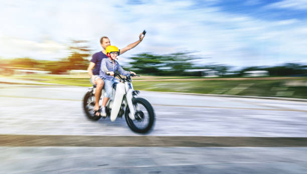 istock Father and son riding a bike and taking selfie 984661238