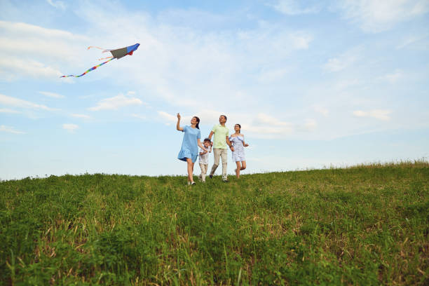 istock Family with a kite runs in nature 984662126