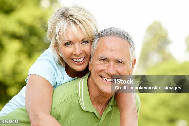 Senior Man Giving Senior Woman A Piggyback Ride Stock Photo - Download Image Now - 60-69 Years, Exercising, Vitality