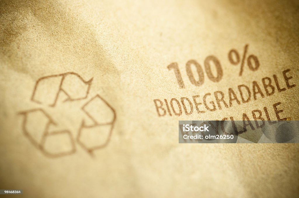 recycled paper, recycling concept words 100% biodegradable ans recyclable written on a kraft recycled paper with arrow sign Biodegradable Stock Photo