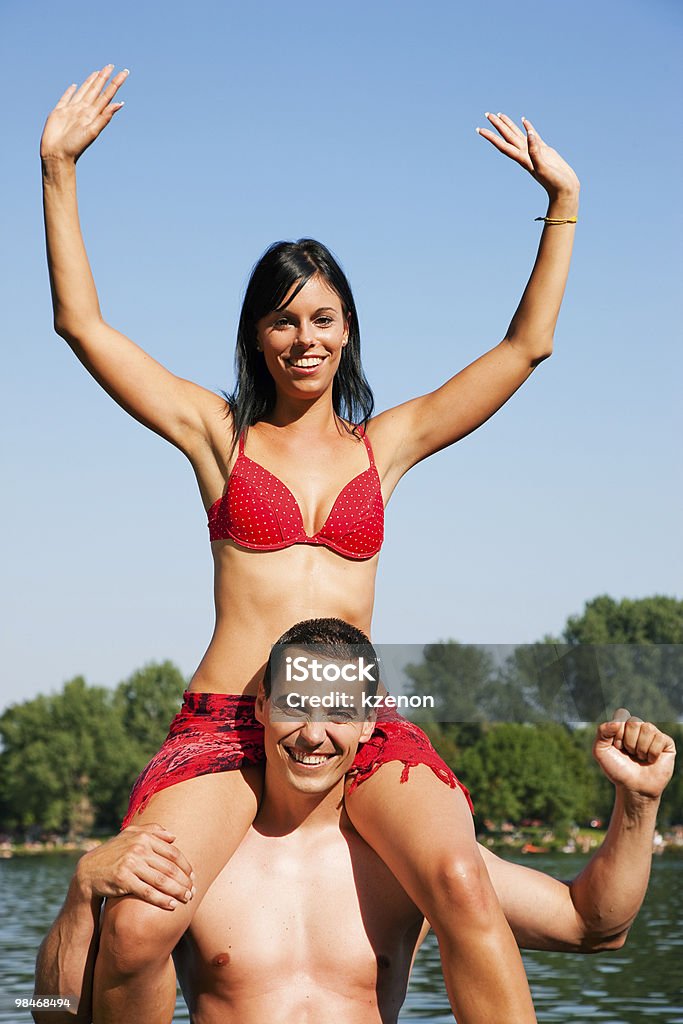 Estate ragazza bikini seduti sulle spalle di uomo - Foto stock royalty-free di Adulto