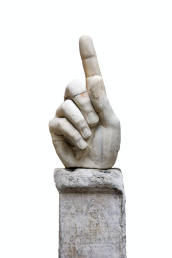 A closeup shot of a white handmade hand clay statue isolated on a black background