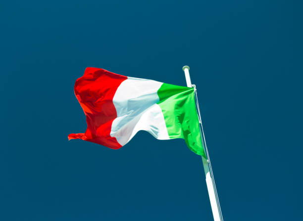 istock italian flag waving in the wind with blue sky as background. 984688988