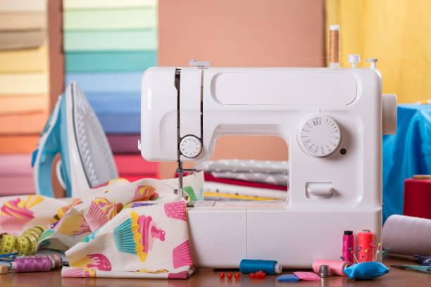 istock Sewing machine in work and accessories, on background of fabric samples 984710822