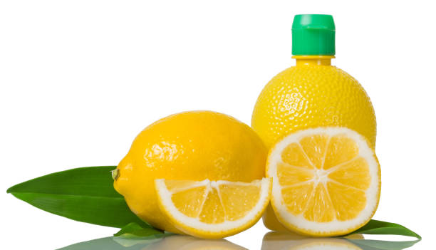istock Lemon juice in bottle, whole fruit and pieces isolated on white 984711224