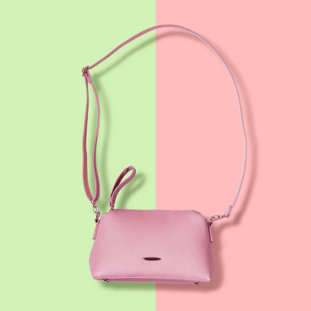 istock Ladies pink pastel handbag with long strap on pink background 984711526