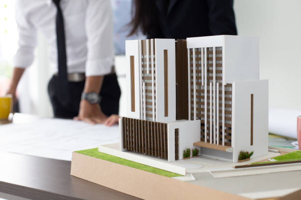istock Close-up building model on table. Architect working with team with building project. 984719516