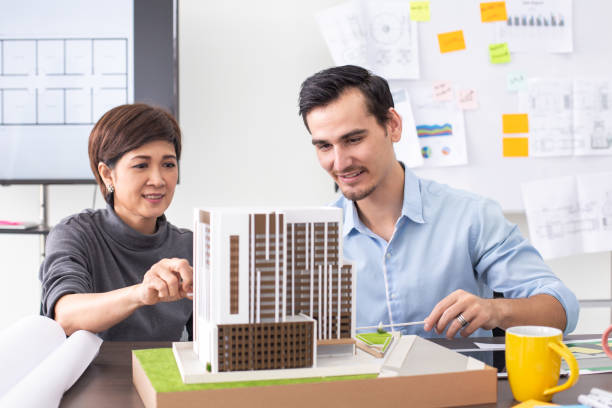 istock Close-up building model on table. Architect working with team with building project. 984719522