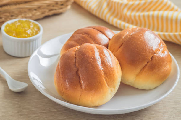 round bun, bread rolls on white plate and pineapple jam - bun imagens e fotografias de stock