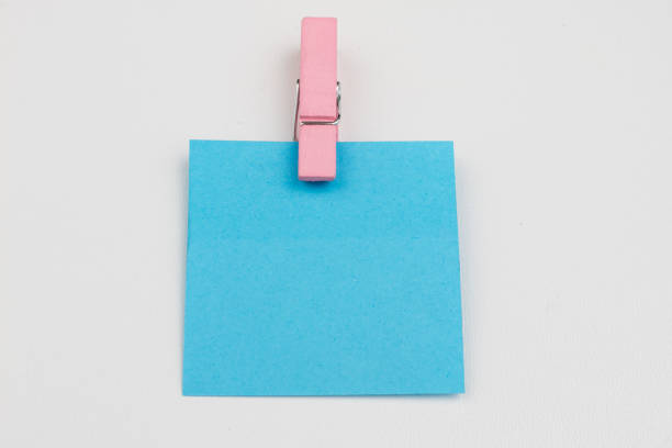 Blank colored sticky notes with clips. Office accessories for listing and memorizing on the table. White background.