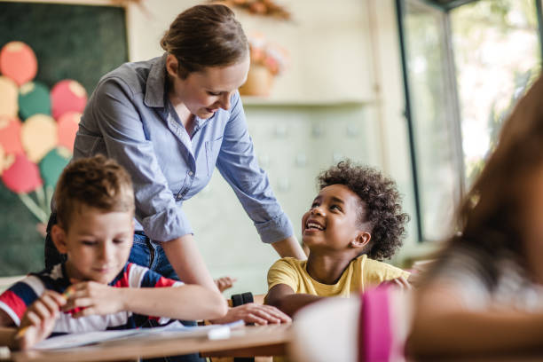 istock Happy black girl talking to her teacher on a class in elementary school. 984741662