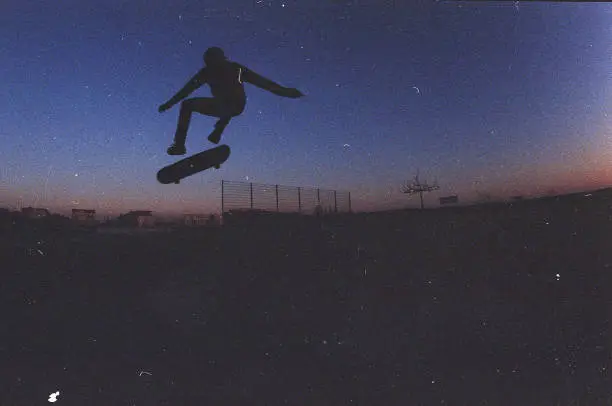 Photo of sunset silhouette of skateboarder kickflip insta flair
