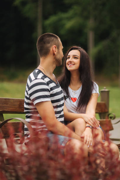 istock Young couple in love spending time together and sit on the bench 984754194
