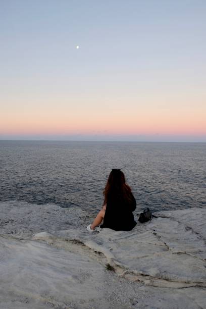 istock Chinese girl on cliff against dramatic sunset sky. 984754480