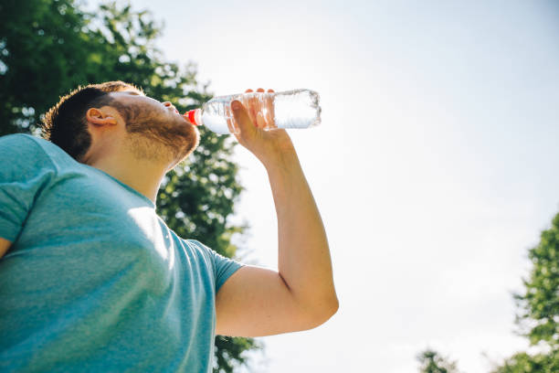 istock man drinking water in hot summer day. copy space 984758856