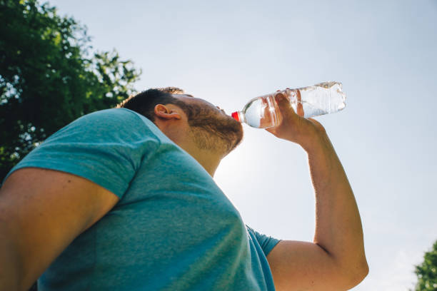 istock man drinking water in hot summer day. copy space 984758902