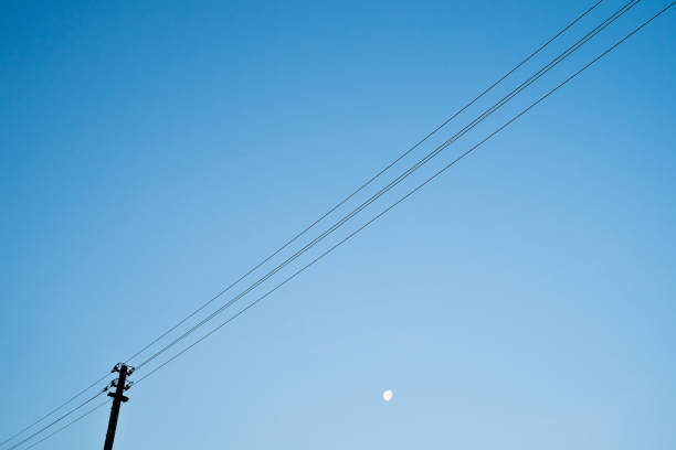 istock High voltage towers with sky background and moon 984767008