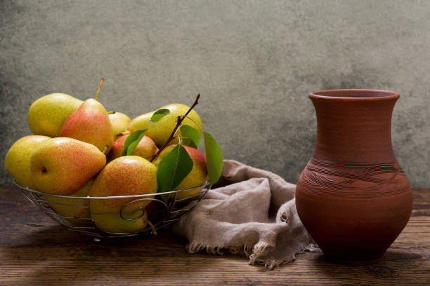 istock pears with leaves in a basket on wooden table 984767334
