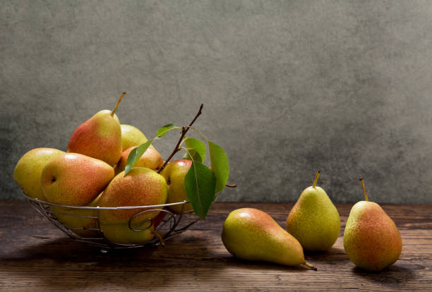 istock pears with leaves in a basket on wooden table 984767360