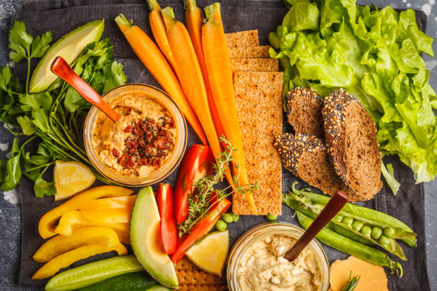 istock Vegetarian Arabic dip hummus with vegetables and different snacks on dark background. Healthy vegan food concept. 984768220