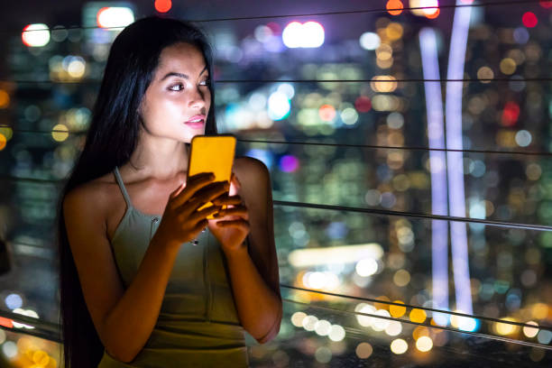 istock Beautiful young woman taking selfie at night 984782616