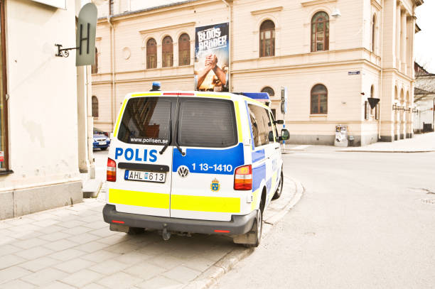 Swedish Police Patrol Van and Cars Parked Outside Sundsvall Visitor/Tourist Information Center Swedish police patrol van parked outside visitor/tourist information center at the centre of Sundsvall City square in Sweden. A movie banner - advertising "Blods Bröder" (blood brothers in Swedish) - overhead riot police stock pictures, royalty-free photos & images
