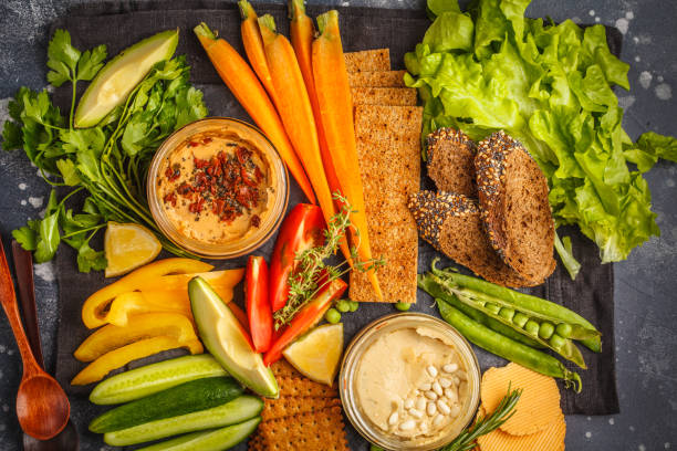 istock Vegetarian Arabic dip hummus with vegetables and different snacks on dark background. Healthy vegan food concept. 984786288