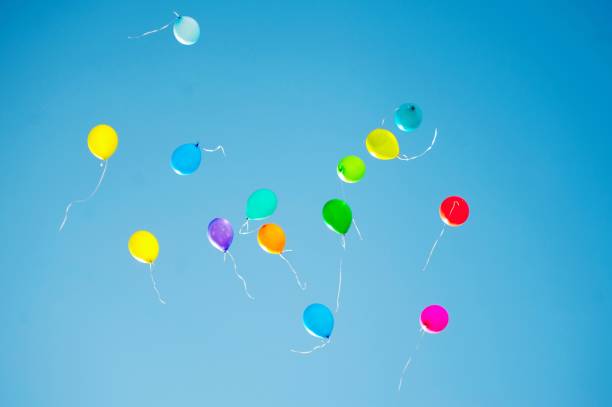 istock multicolored balloons are flying in the blue sky 984787422