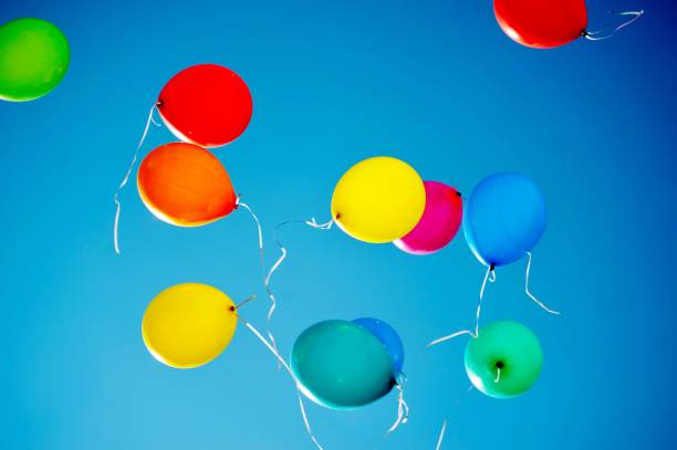 istock multicolored balloons are flying in the blue sky 984787544