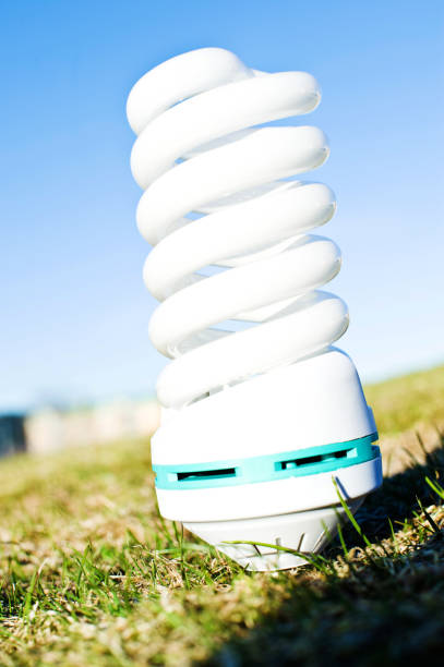 White Spiral Electric Lamp Bulb On Green Grass White Spiral Electric Bulb On Green Grass photodiode stock pictures, royalty-free photos & images