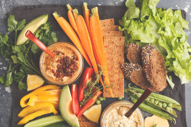 istock Vegetarian Arabic dip hummus with vegetables and different snacks on dark background. Healthy vegan food concept. 984787790