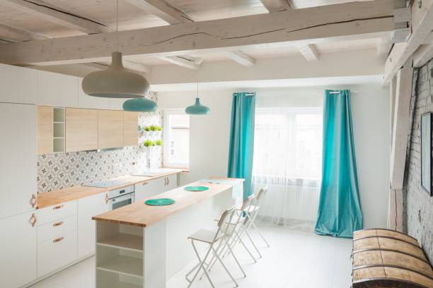 istock Open bright kitchen with white furniture. Island kitchen. 984790340