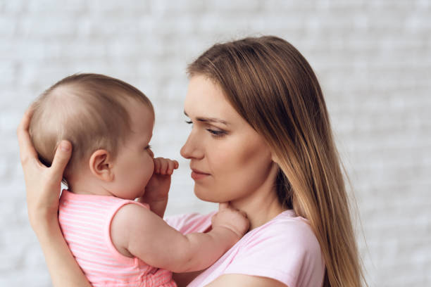 istock Cute baby hugging with cheerful young mother 984801998